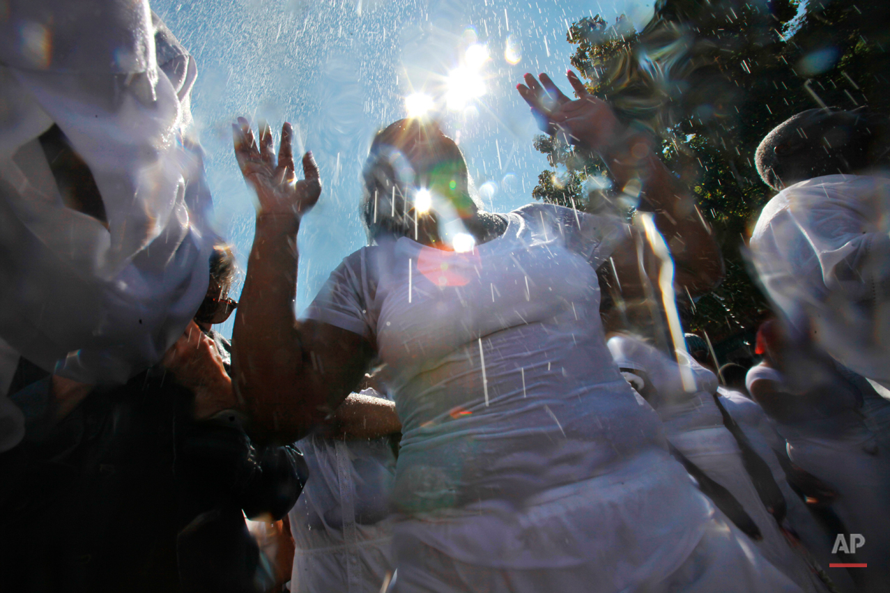  Water rains down as a fire hose sprays the crowd during a spiritual mass baptism at the United House of Prayer for All People in Washington, on Sunday, Aug. 29, 2010. The 84th annual mass water baptism celebrates the end of the church's annual "holy