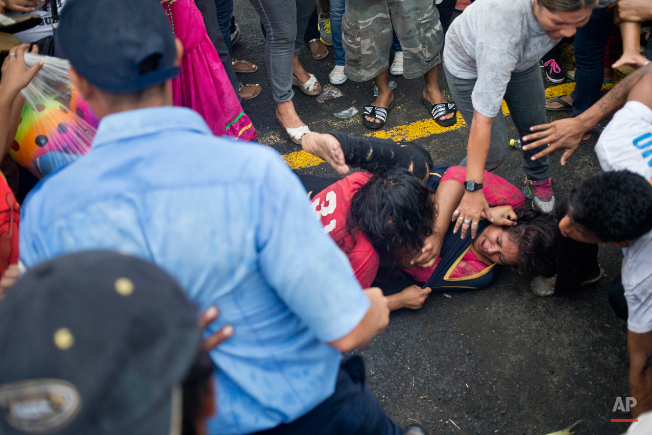  In this Aug. 10, 2015 photo, two women fight during the feast of Managua's patron saint, Santo Domingo de Guzman, in Managua, Nicaragua. According to Nicaraguan folklorist Wilmor Lopez the celebration is a mix of original indigenous and Catholic tra