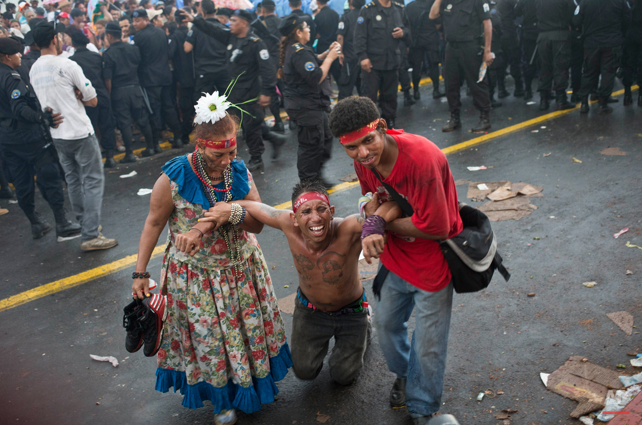  In this Aug. 10, 2015 photo, Jorge Carbajal, 30, pays a promise made to Managua's patron saint, Santo Domingo de Guzman, as he advances on his knees, assisted by relatives, in Managua, Nicaragua. The first 10 days of August are reserved for the carn