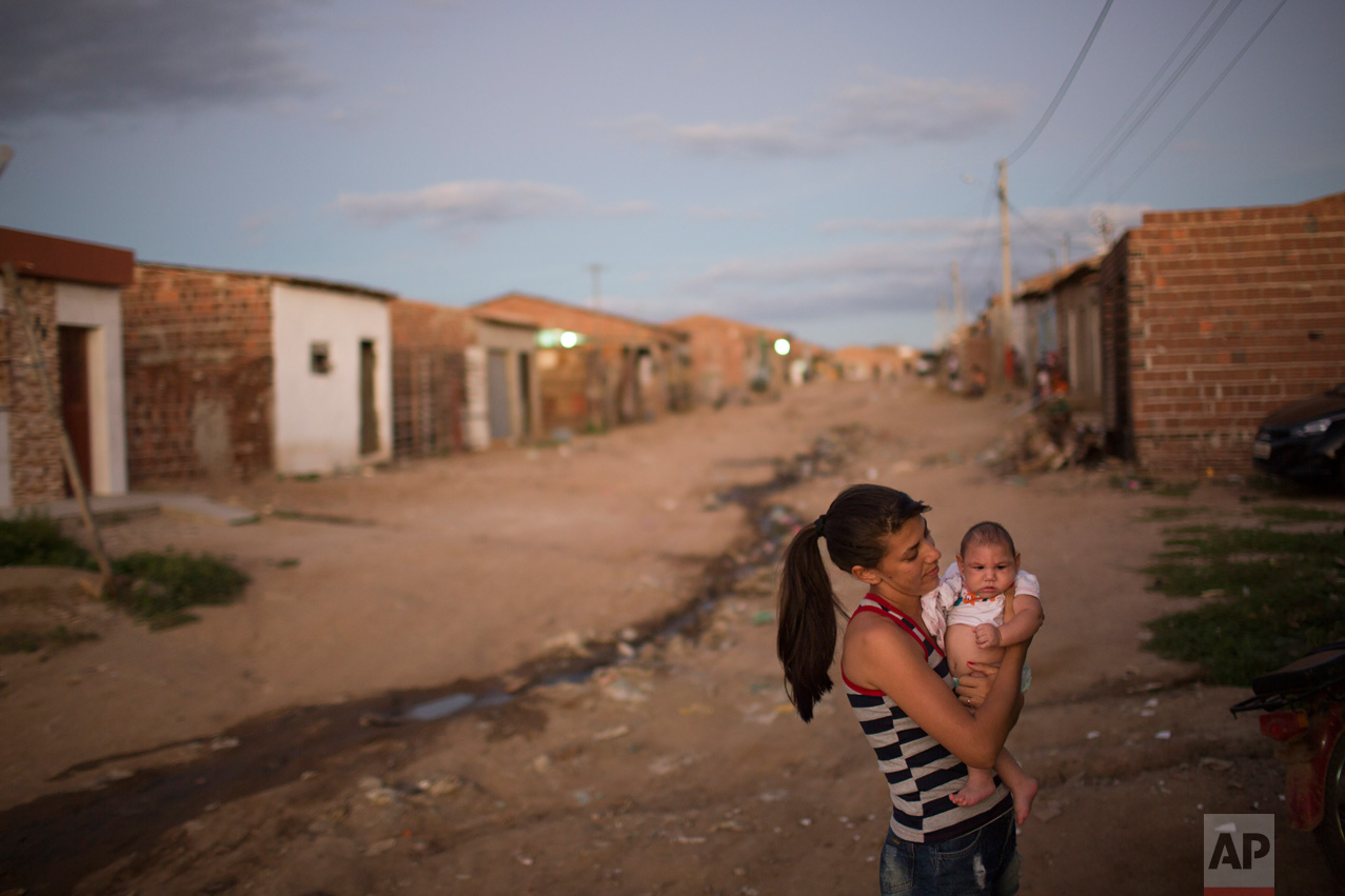  Angelica Pereira holds her daughter Luiza, who was born with microcephaly, outside her house in Santa Cruz do Capibaribe, Pernambuco state, Brazil, Saturday, Feb. 6, 2016. The Zika virus, spread by the Aedes aegypti mosquito, thrives in people's hom
