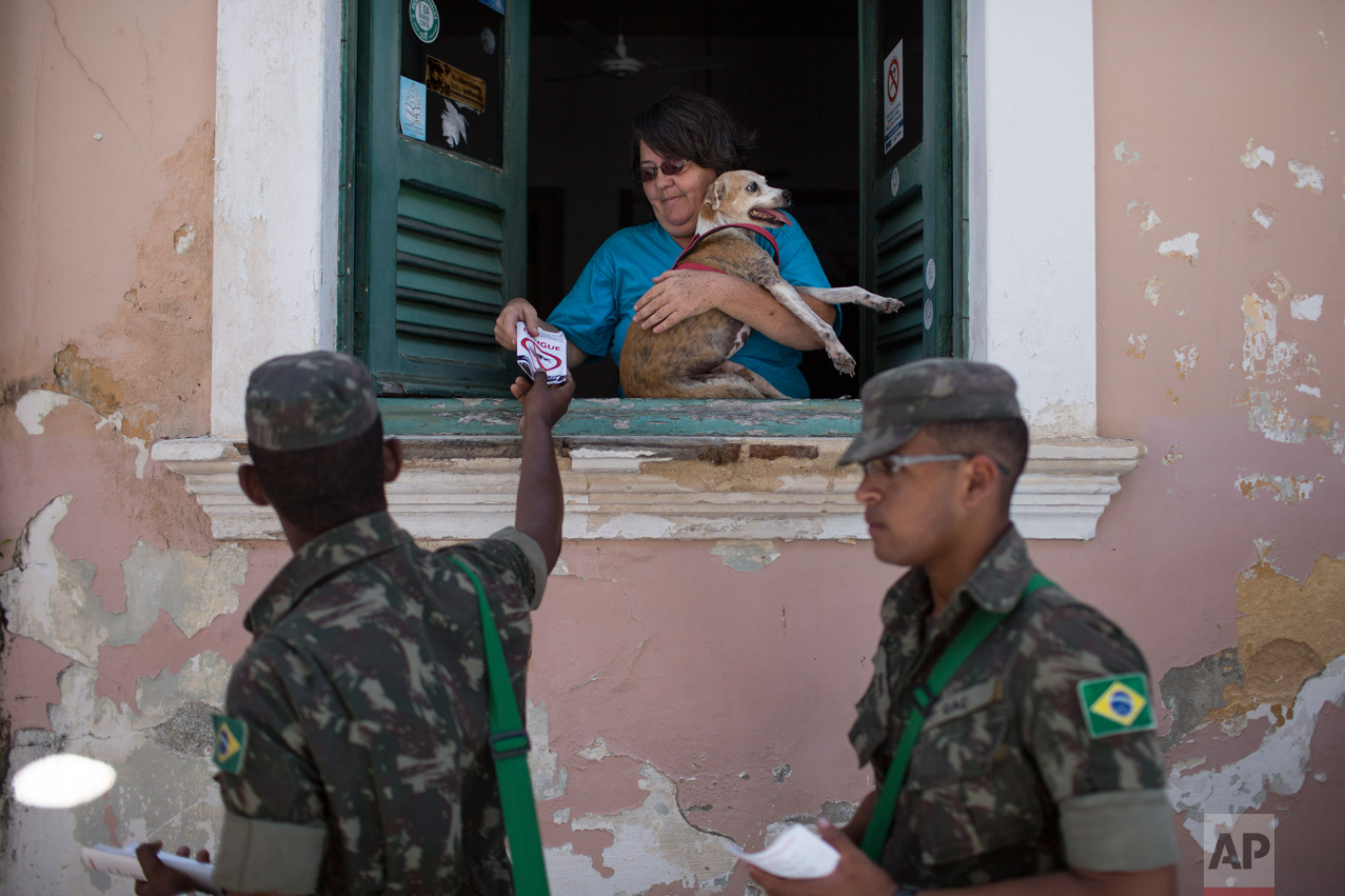  Brazilian Army soldiers distribute flyers with information on how to combat the Aedes aegypti during the "Burial of the Mosquito" carnival block parade in Olinda, Pernambuco state, Brazil, Friday, Feb. 5, 2016. The parade that happens every year dur