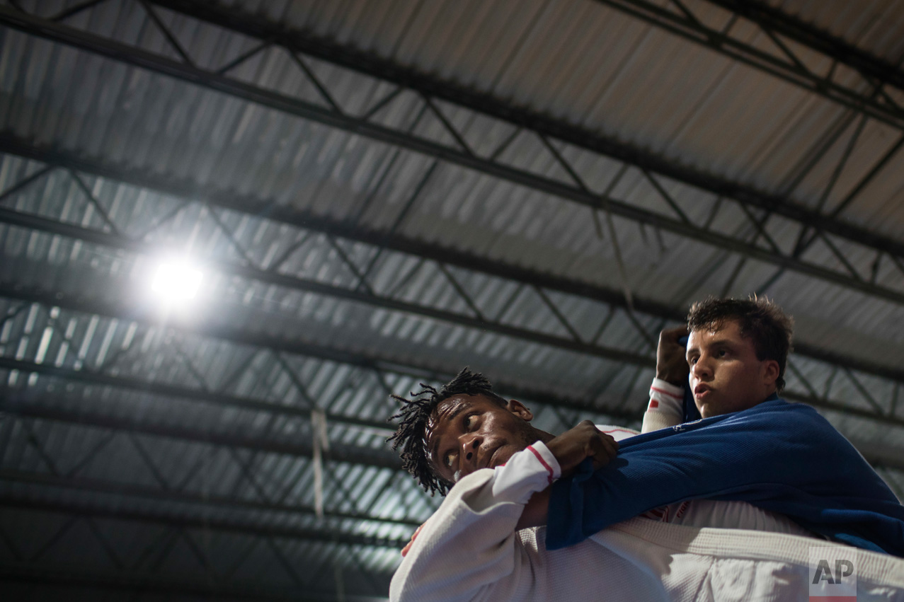  In this May 27, 2016 photo, Popole Misenga, a refugee from the Democratic Republic of Congo, left, practices judo in hopes of making the cut for an Olympic team of refugee athletes, at the Reacao Institute in Rio de Janeiro, Brazil. With the help of