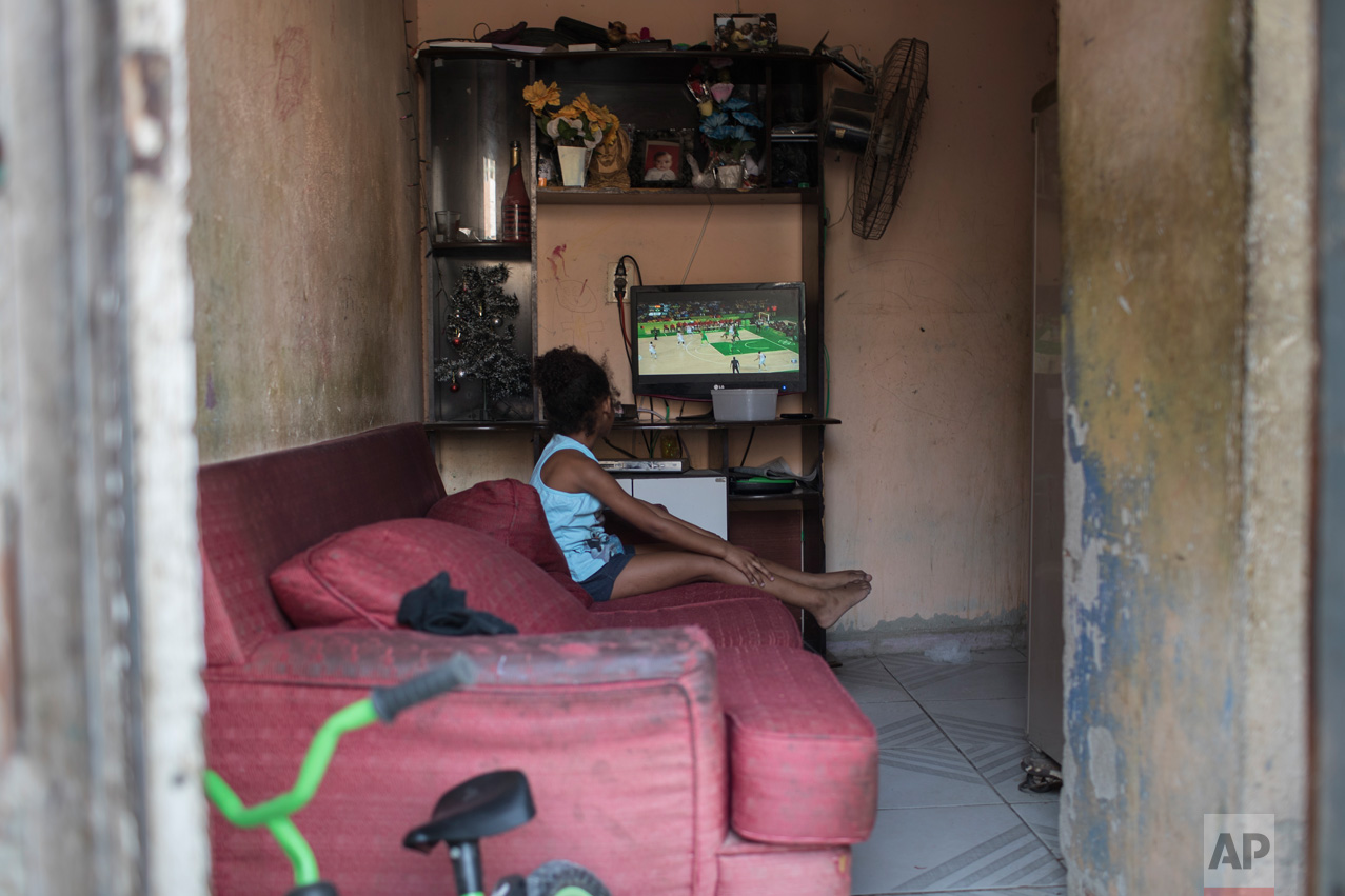  A girl watches on a television the men's basketball game between Brazil and Spain at the 2016 Summer Olympics in Rio de Janeiro, Brazil, Tuesday, Aug. 9, 2016. (AP Photo/Felipe Dana) 