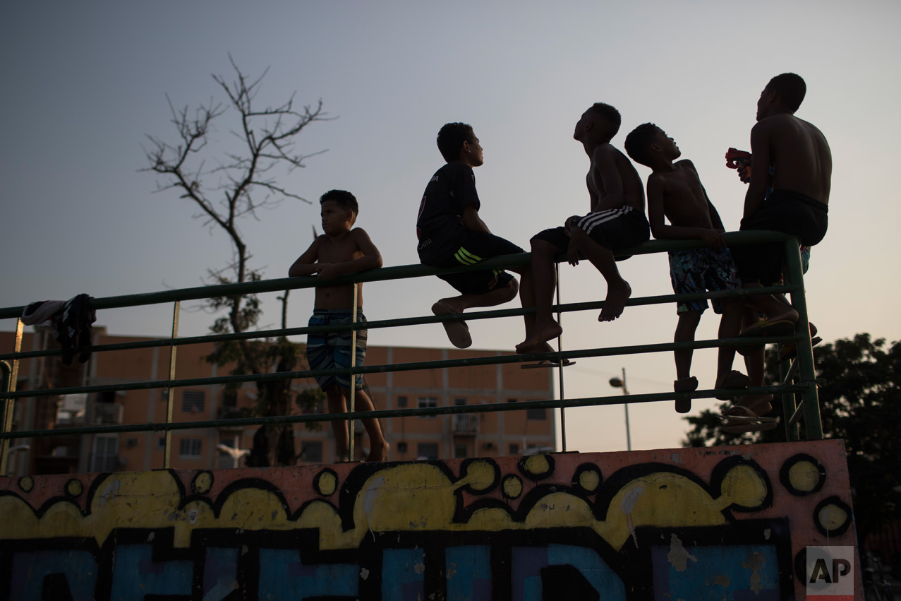  Boys look up at flying kites at the manguinhos slum during the 2016 Summer Olympics in Rio in Rio de Janeiro, Brazil, Tuesday, Aug. 9, 2016. (AP Photo/Felipe Dana) 