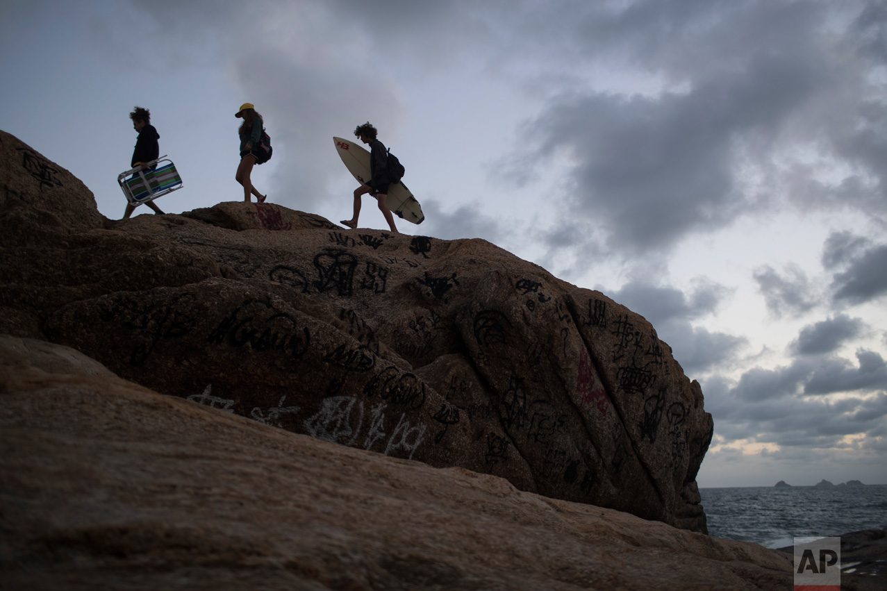  People walk on the rocks of Arpoador beach as the sun sets during the 2016 Summer Olympics in Rio de Janeiro, Brazil, Friday, Aug. 12, 2016. (AP Photo/Felipe Dana) 