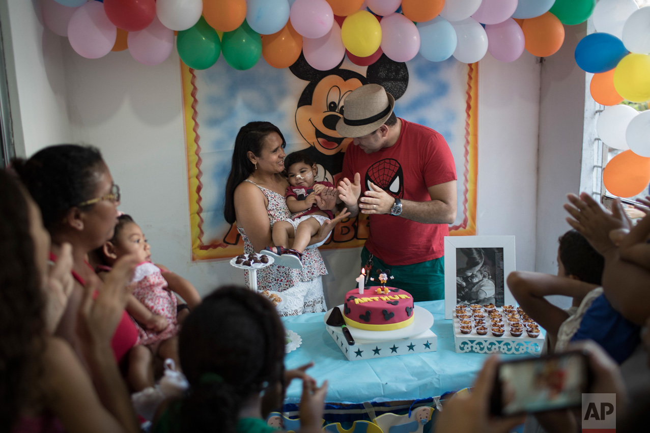  In this Oct. 1, 2016 photo, Rozilene Ferreira and her husband Elias Rodrigo celebrate the one-year birthday of their son Arthur, who was born with microcephaly, in Recife, Pernambuco state, Brazil. Arthur has started taking high-calorie formula thro
