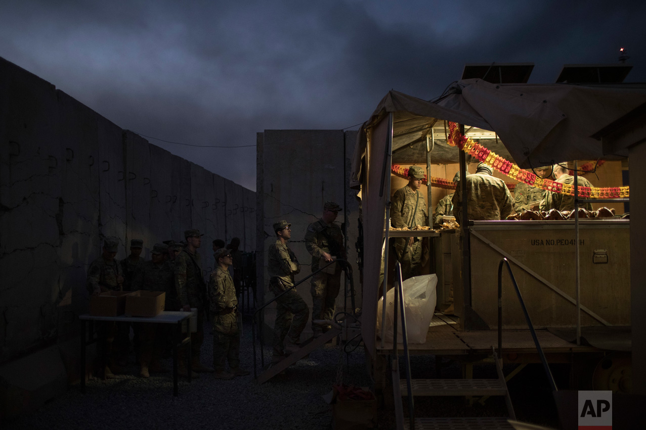  U.S. military personnel wait in line for Thanksgiving dinner at a coalition air base in Qayara south of Mosul, Iraq, Thursday, Nov. 24, 2016. (AP Photo/Felipe Dana) 