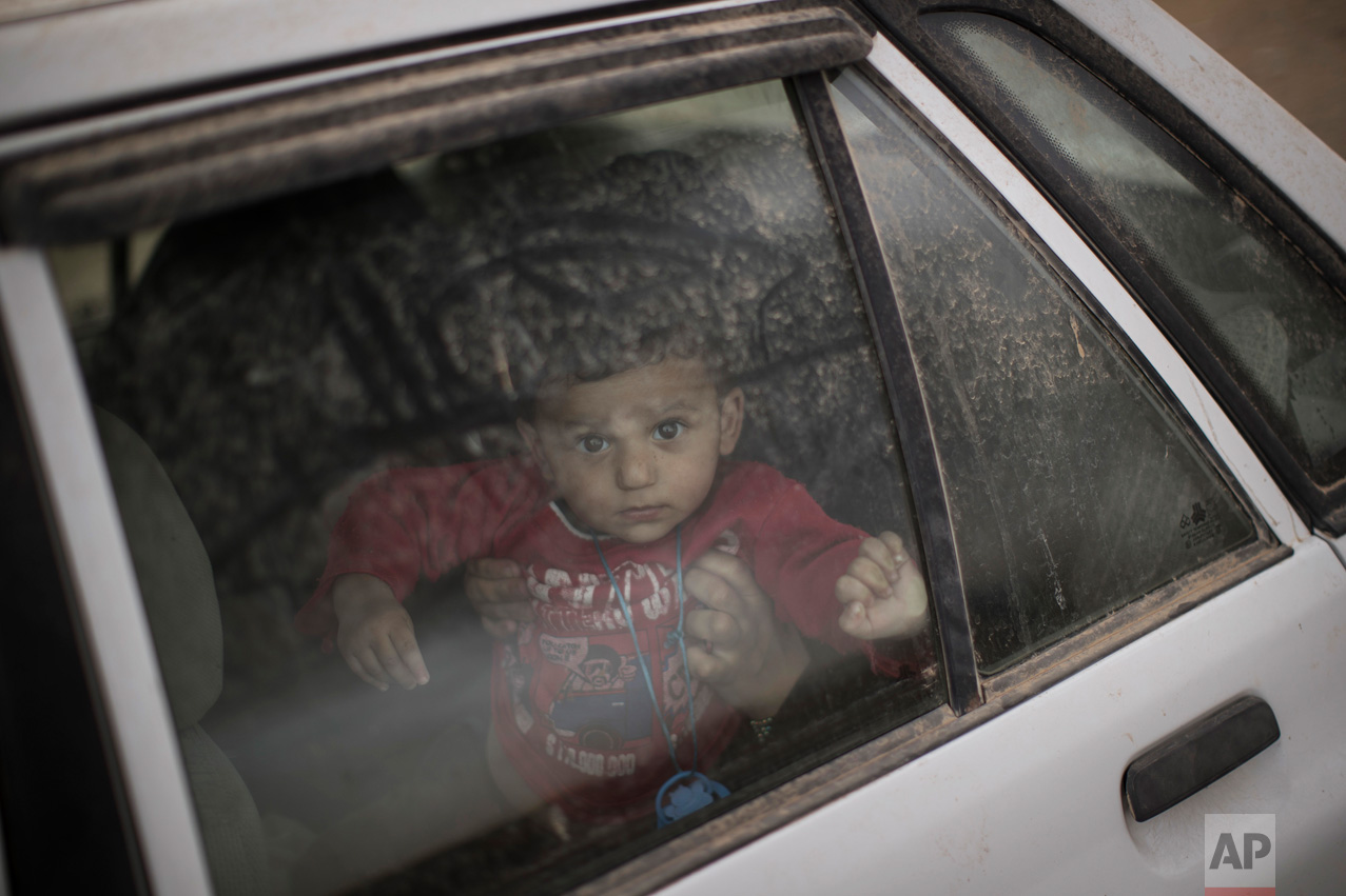  A boy looks out from a car window at a checkpoint near Qayara, south of Mosul, Iraq, Tuesday, Nov. 1, 2016. The U.N. human rights office is lauding efforts by the U.S.-led coalition in the battle against the Islamic State group in Mosul. The office 