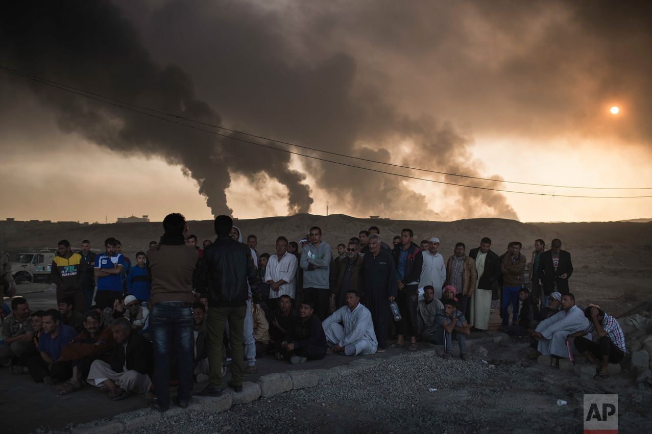 Men are held by Iraqi national security agents, to be interrogated at a checkpoint, as oil fields burn in Qayara, south of Mosul, Iraq, Saturday, Nov. 5, 2016. Islamic State fighters launch counterattacks in the thin strip of territory Iraqi special