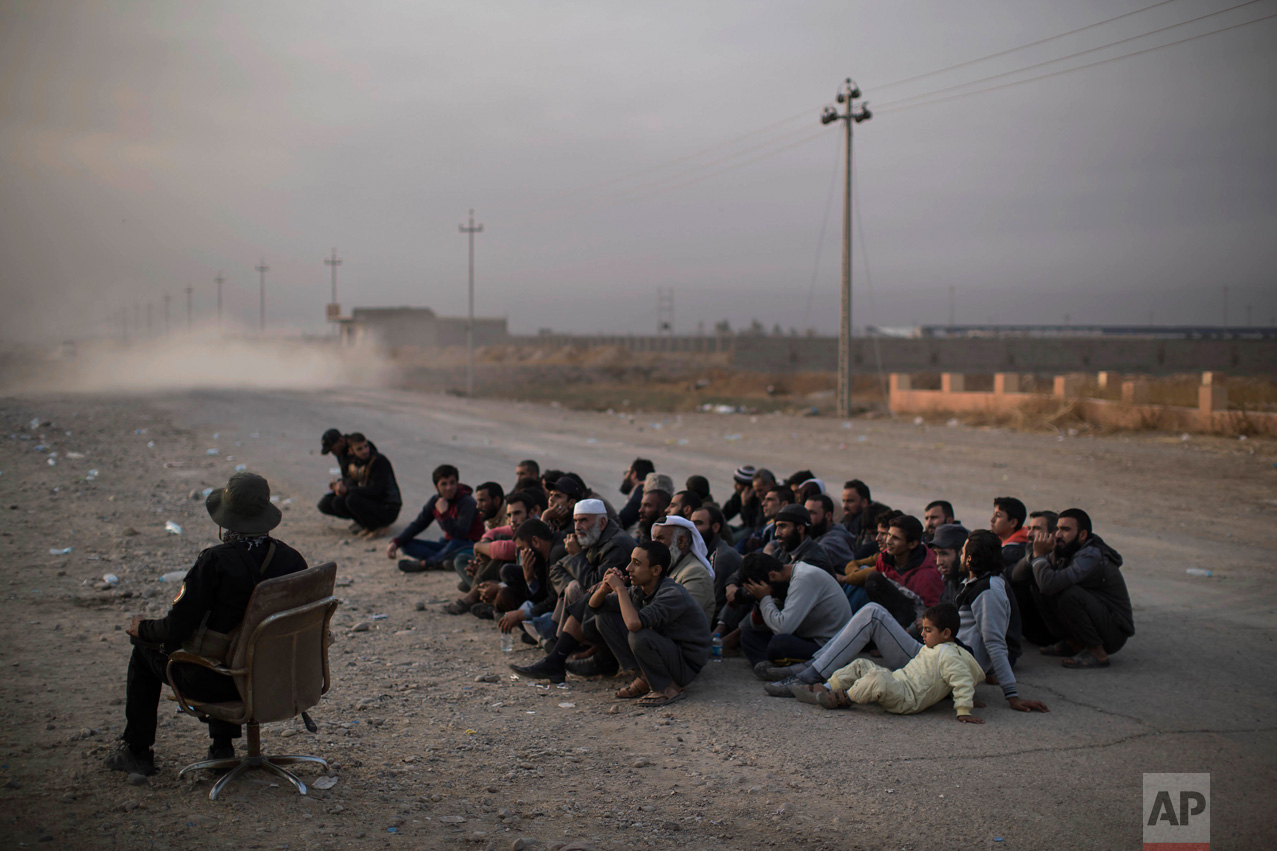 Internally displaced men sit as they wait for their documents to be checked after fleeing fighting between the Iraqi forces and Islamic State, at a checkpoint near Bartella, east of Mosul, Iraq, Monday, Nov. 14, 2016. (AP Photo/Felipe Dana) 