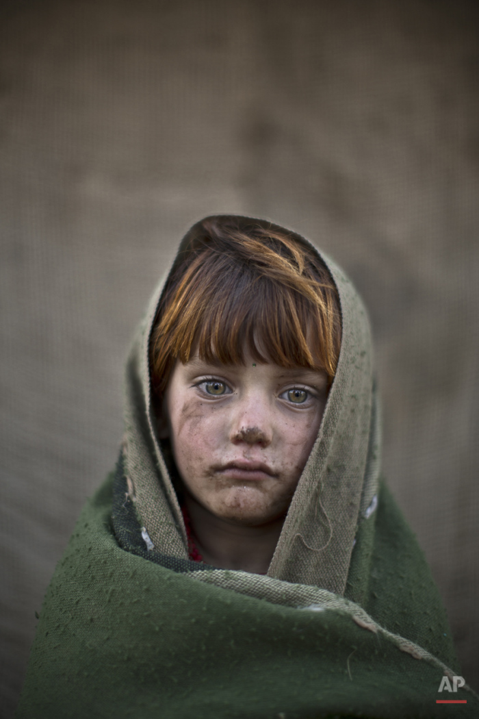  In this Friday, Jan. 24, 2014, photo, Afghan refugee girl, laiba Hazrat, 6, poses for a picture, while playing with other children in a slum on the outskirts of Islamabad, Pakistan. For more than three decades, Pakistan has been home to one of the w