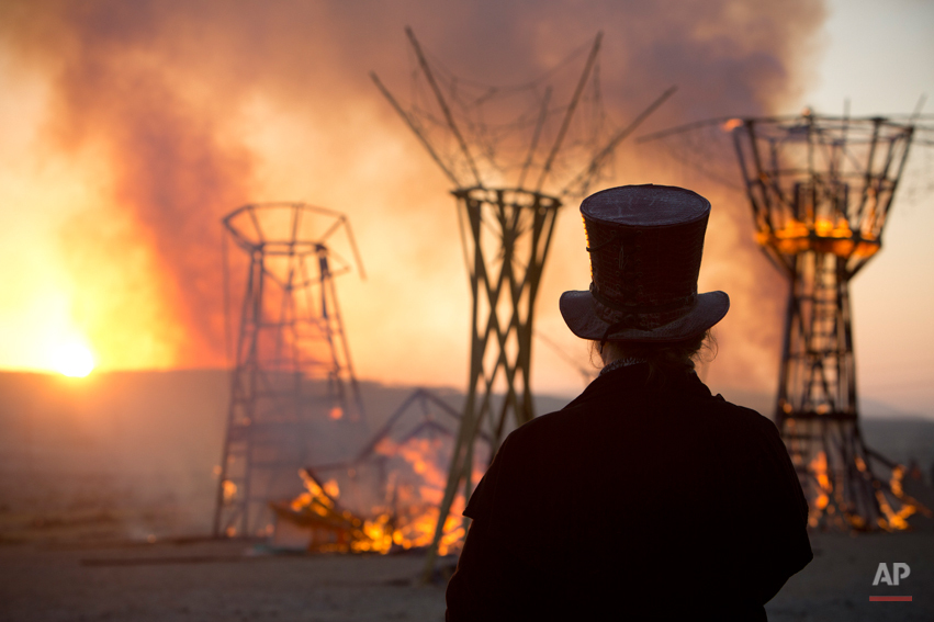  In this photo taken Saturday, June 7, 2014, a man looks at a wooden sculpture that was set on fire during Israelís first Midburn festival, modeled after the popular Burning Man festival held annually in the Black Rock Desert of Nevada, in the desert