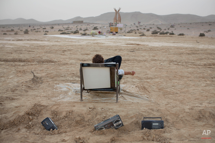  In this photo taken Wednesday, June 4, 2014, an Israeli man rests on a couch during Israelís first Midburn festival, modeled after the popular Burning Man festival held annually in the Black Rock Desert of Nevada, in the desert near the Israeli kibb