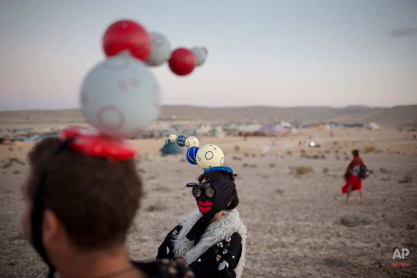  In this photo taken Friday, June 6, 2014, Israelis in costumes walk around the playa during Israelís first Midburn festival, modeled after the popular Burning Man festival held annually in the Black Rock Desert of Nevada, in the desert near the Isra