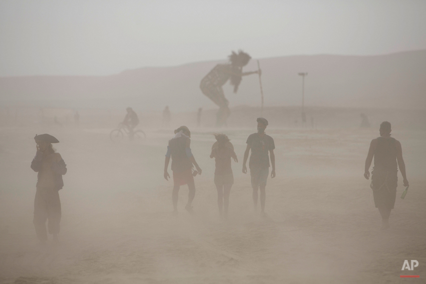  In this photo taken Thursday, June 5, 2014, people walk in the dusty playa during Israelís first Midburn festival, modeled after the popular Burning Man festival held annually in the Black Rock Desert of Nevada, in the desert near the Israeli kibbut