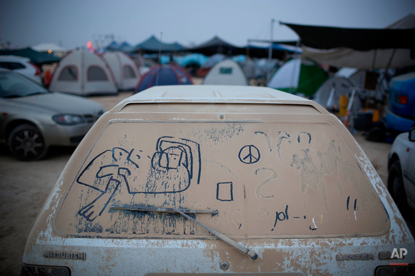  In this photo taken Wednesday, June 4, 2014, hand writing and doodles adorn a dusty car during Israelís first Midburn festival, modeled after the popular Burning Man festival held annually in the Black Rock Desert of Nevada, in the desert near the I