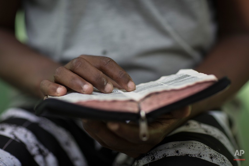  In this May 9, 2014 photo, a former drug user reads the bible at the God's Love rehabilitation center in Rio de Janeiro, Brazil. Pastor Celio Ricardo offers them a roof in a makeshift shelter in a nearby neighborhood, a simple structure next to his 