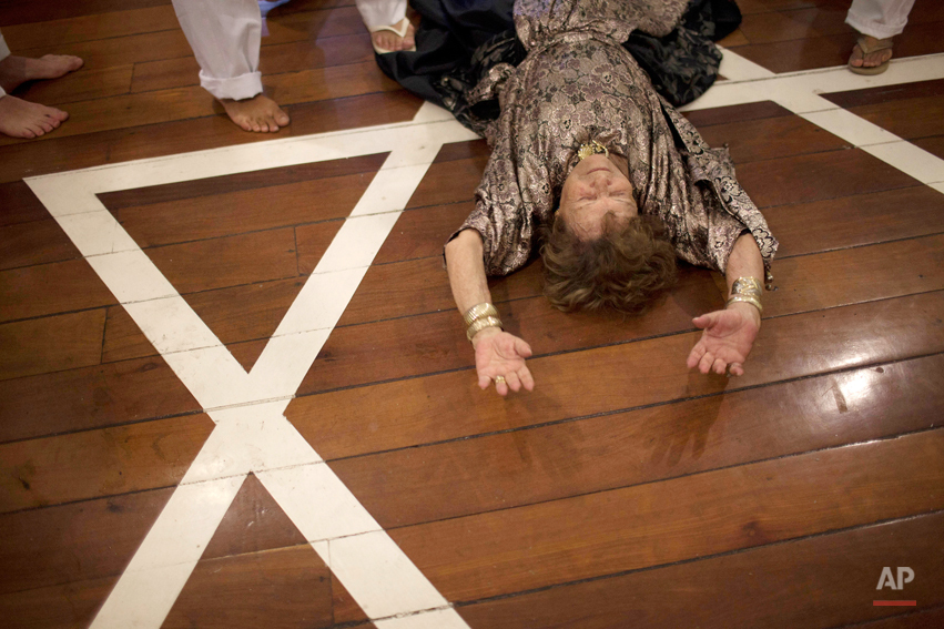  In this photo taken on Nov.  25, 2011, Rosa Cardoso, 89, lies on the floor during the 'Exu' and 'Pomba Gira' ceremony at an Umbanda house of worship in Rio de Janeiro, Brazil. Intolerance and outright hostility against Umbanda, as well as against Br