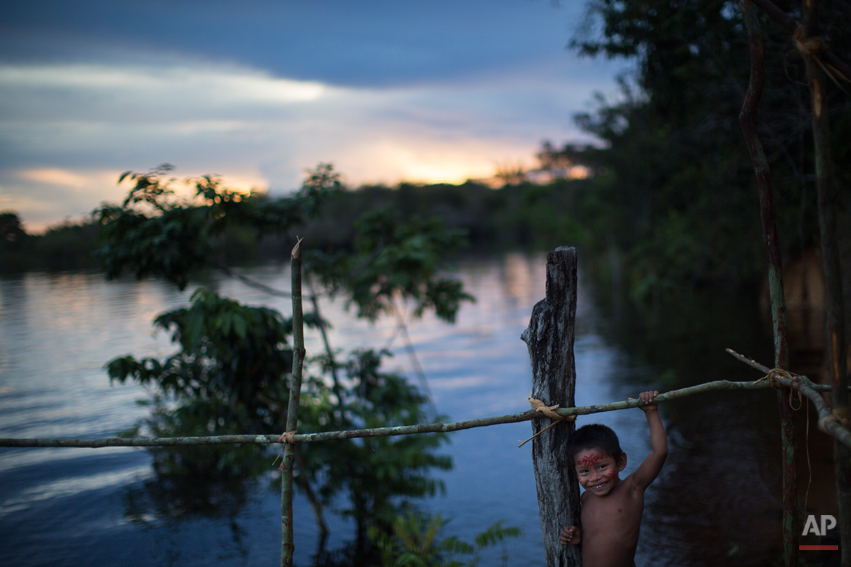  An indigenous boy plays near the Rio Negro river during sunset in the Tatuyo indigenous community, near Manaus, Brazil, Monday, May 19, 2014. Manaus is one of the host cities for the 2014 World Cup in Brazil. (AP Photo/Felipe Dana) 