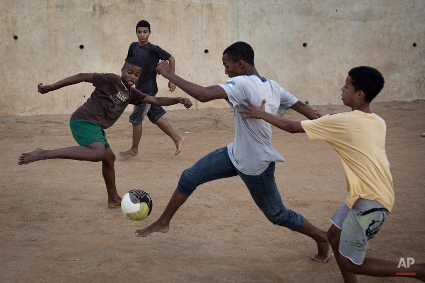 Young residents play soccer at the Sao Carlos slum in Rio de Janeiro, Brazil, Monday, May 12, 2014. As opening day for the World Cup approaches, people continue to stage protests, some about the billions of dollars spent on the World Cup at a time o