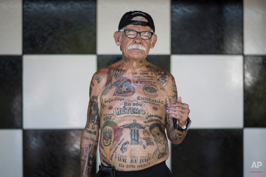  In this May 8, 2014 photo, soccer fan Delneri Viana, 69, poses for a photo in his home, decorated with Botafogo colors in Rio de Janeiro, Brazil. Aside from the 83 and counting tattoos, the gray-haired man with a full, chalky mustache sports finger 