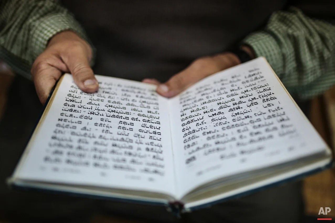 In this Wednesday, Oct. 28, 2015 photo, a Jewish man reads the Torah at La Ghriba, the oldest synagogue in Africa, on the Island of Djerba, southern Tunisia. The Jewish community in the resort island of Djerba traces its roots all the way back to Babylonian exile of 586 B.C., and is one of the few communities of its kind to have survived the turmoil around the creation of Israel, when more than 800,000 Jews across the Arab world either emigrated or were driven from their homes. (AP Photo/Mosa'ab Elshamy)