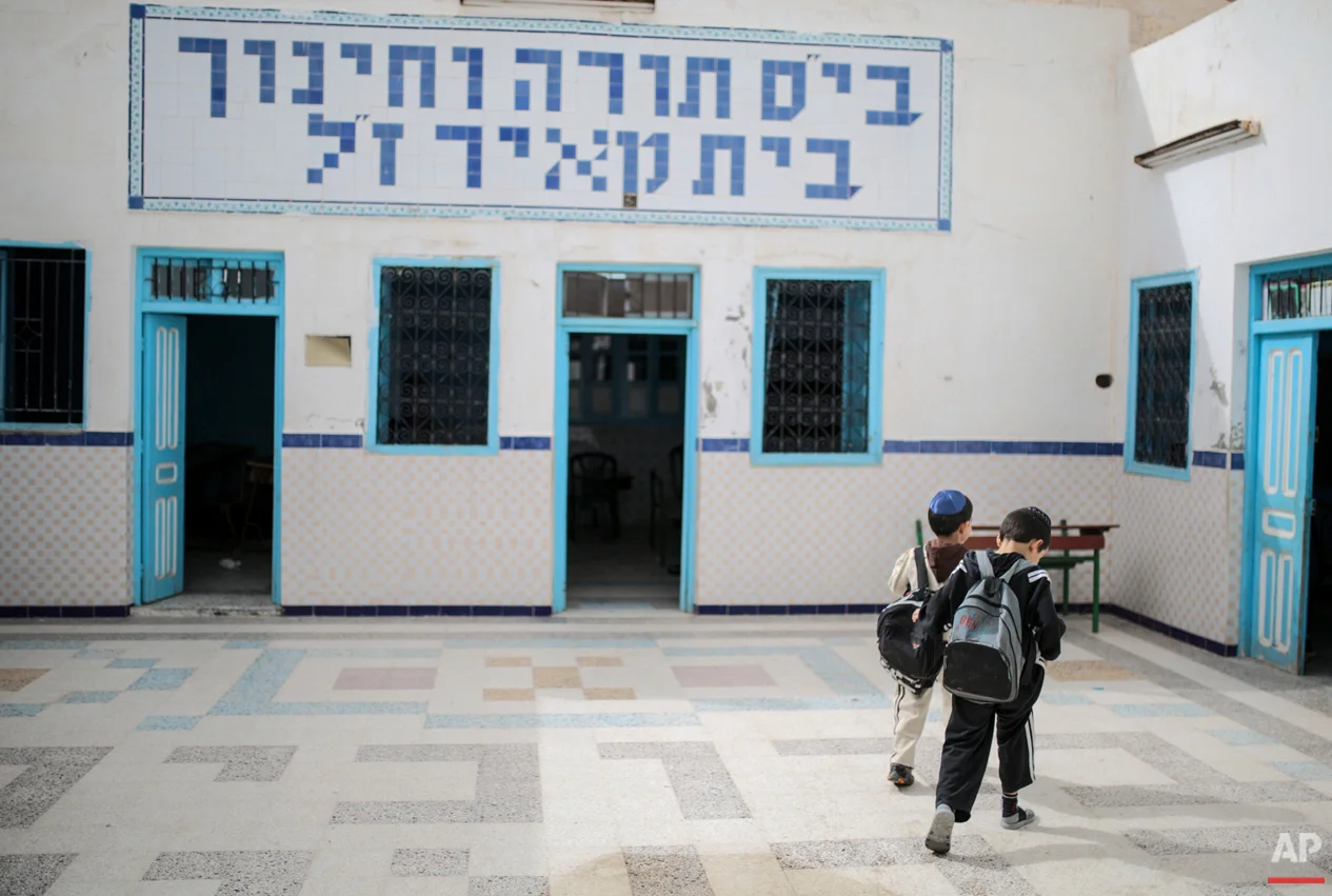 In this Friday, Oct. 30, 2015 photo, boys walk inside a Talmudic school at Hara Kbira, the main Jewish neighbourhood on the Island of Djerba, southern Tunisia. When school lets out, the streets around the ancient synagogue on this Tunisian island fill with rambunctious boys wearing Jewish kippahs and girls in long skirts, shouting to each other in Hebrew, Arabic and French. (AP Photo/Mosa'ab Elshamy)