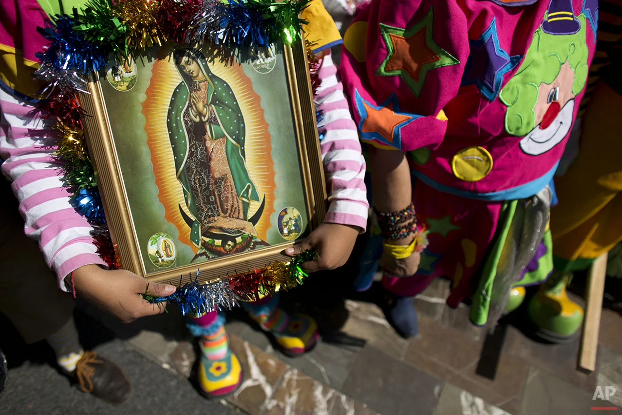 A clown carries a picture of the Virgin of Guadalupe, as she waits to enter the Basilica of Our Lady of Guadalupe in Mexico City, Monday, Dec. 14, 2015. Hundreds of clowns belonging to various clown associations made their annual pilgrimage to the Basilica on Monday to pay their respects to the Virgin of Guadalupe, Mexico's patron saint. (AP Photo/Rebecca Blackwell)