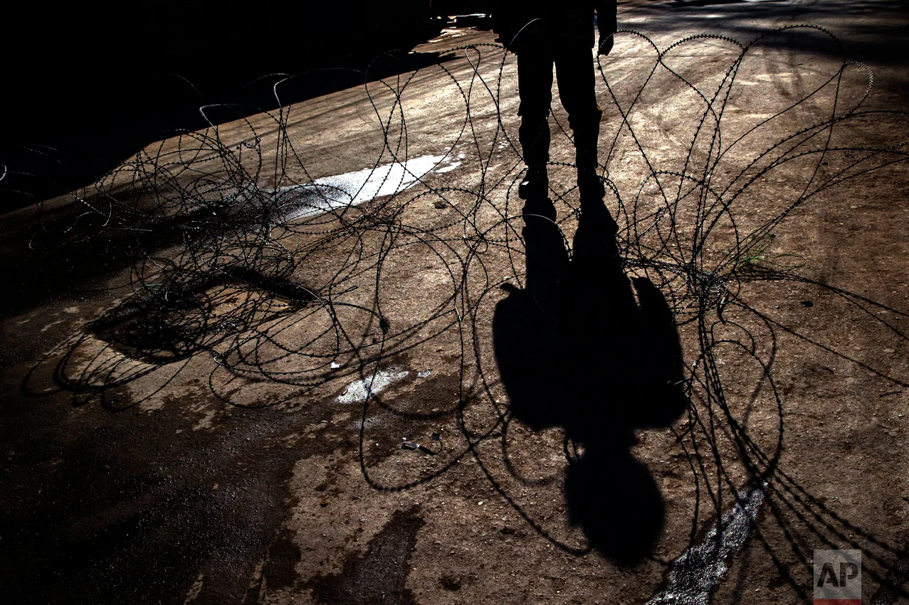 A shadow of an Indian paramilitary soldier is cast on barbed wire at a checkpoint during curfew in Srinagar, Indian controlled Kashmir, Friday, Feb. 10, 2017. Authorities imposed a curfew in some parts of Indian-controlled Kashmir's main city to prevent a protest march to the disputed Himalayan region's office of United Nations Military Observer Group in India and Pakistan (UNMOGIP) called by separatist leaders seeking end of Indian rule. (AP Photo/Dar Yasin)