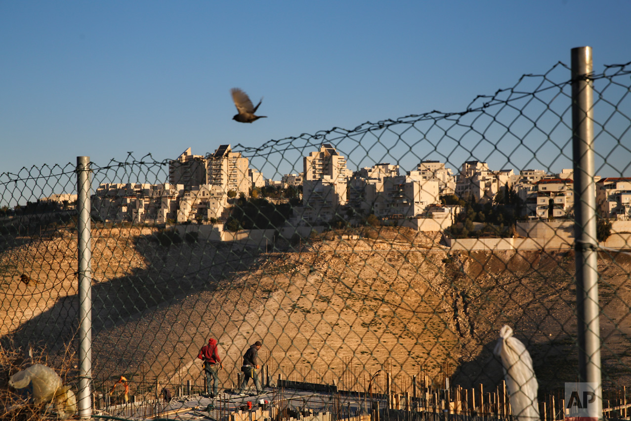 Palestinian laborers work at a construction site in a new housing project in the Israeli settlement of Maale Adumim, near Jerusalem, Tuesday, Feb. 7, 2017. A Palestinian Cabinet minister on Tuesday called on the international community to punish Israel for a contentious new law, just hours after the Israeli parliament adopted the bill to retroactively legalize thousands of West Bank settlement homes built unlawfully on private Palestinian land. (AP Photo/Oded Balilty)