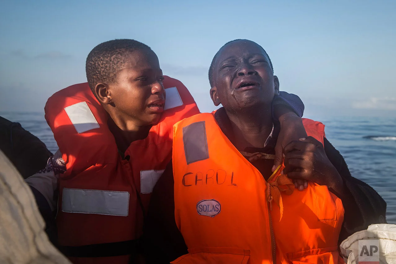 In this Thursday, July 28, 2016 photo, by photographer Santi Palacios which won second prize in the General News, Singles, category of the World Press Photo contest shows an 11-year-old girl from Nigeria, right, who said her mother died in Libya, crying next to her 10-year-old brother aboard an NGO rescue boat, on 28 July 2016. The children had sailed for hours in an overcrowded rubber boat with other refugees during a rescue operation on the Mediterranean Sea, about 23 kilometers north of Sabratha, Libya. (AP Photo/Santi Palacios)