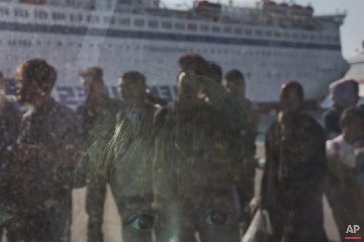 A child looks out from a window of a bus upon arriving by a ferry from the Greek island of Lesbos at the Athens' port of Piraeus on Thursday, Oct. 15, 2015. The international Organization for Migration said than more than 593,000 people have crossed into Europe this year — of which 453,000 traveled from Turkey to Greece, which has faced a massive influx of people from Syria.(AP Photo/Petros Giannakouris)