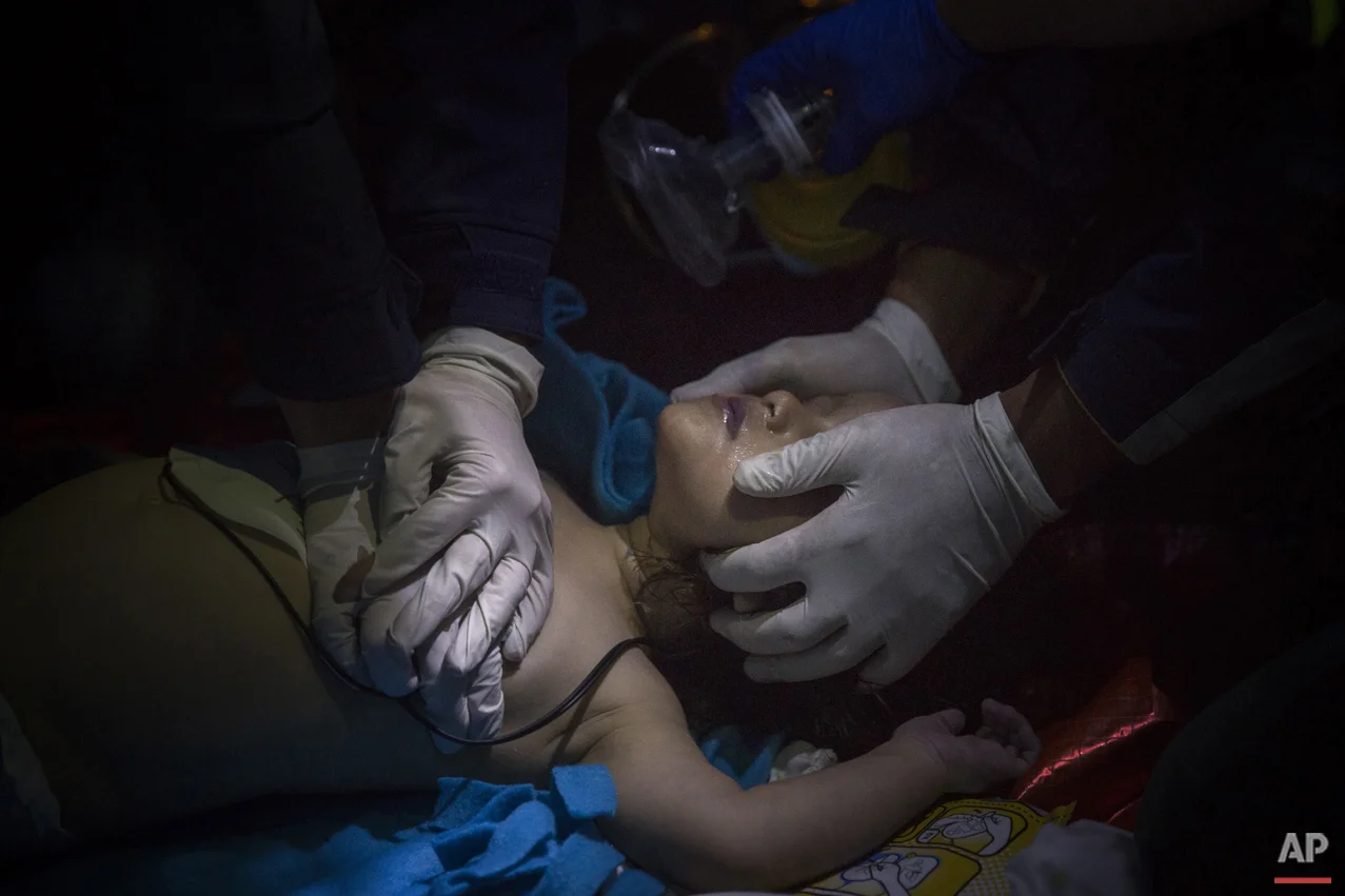 Paramedics and doctors try to revive a baby after a boat with refugees and migrants sunk while was crossing the Aegean sea from Turkey to the Greek island of Lesbos on Wednesday, Oct. 28, 2015. The condition of the child is not known. A 7-year-old boy died off Lesbos, where most migrants land, while a 12-month-old girl was in critical condition in hospital from the same boat accident. (AP Photo/Santi Palacios)