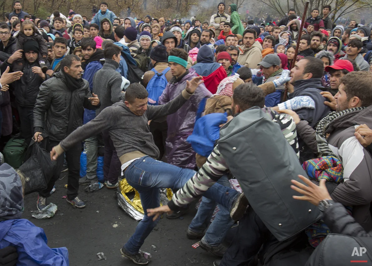 Migrants scuffle as they wait to cross to Austria, in Sentilj, Slovenia, Thursday, Oct. 29, 2015. Asylum-seekers hoping to reach Western Europe turned to crossing Slovenia after Hungary closed its border with Croatia with a barbed-wire fence. (AP Photo/Darko Bandic)
