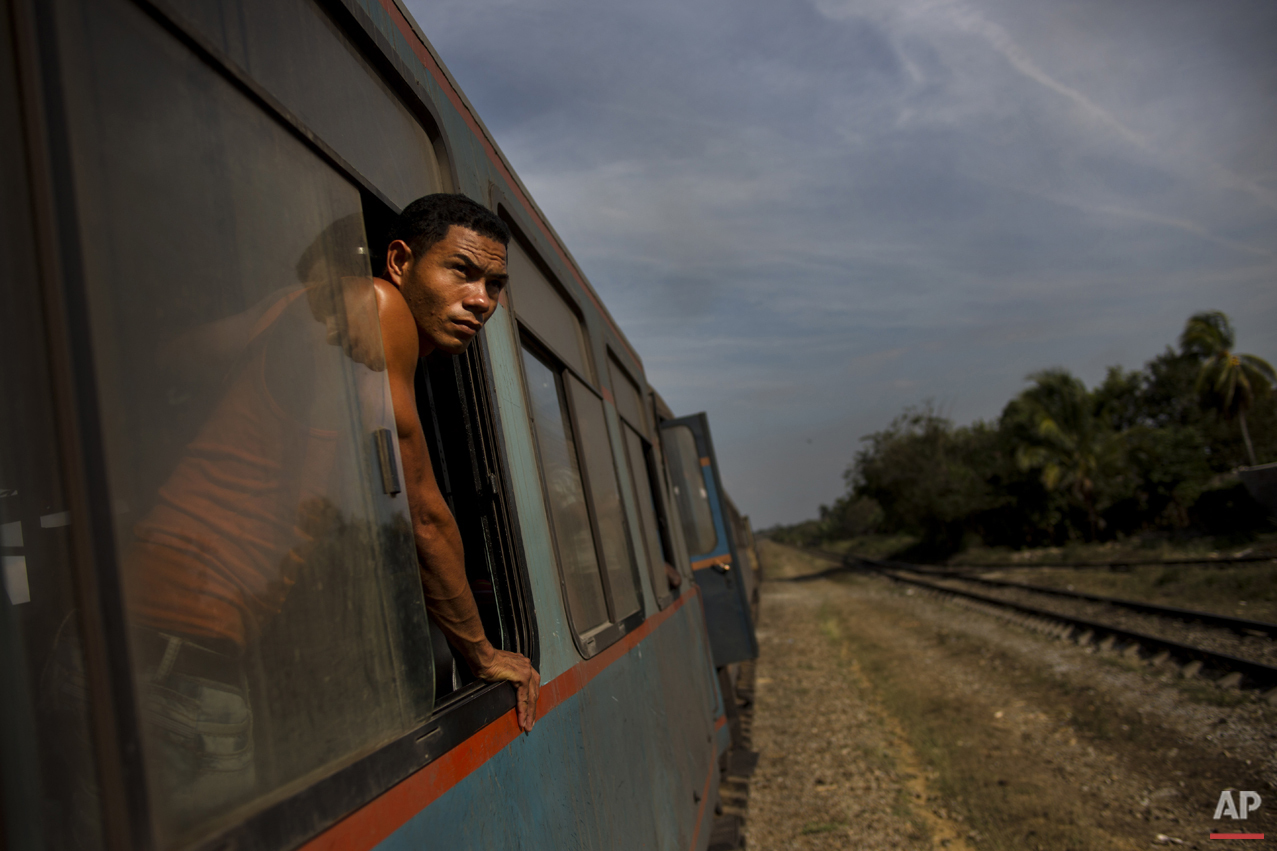  In this March 23, 2015 photo, a train passenger looks out at the countryside between Ciego de Avila and Santa Clara, Cuba. While the island is slowly modernizing its rail system, it remains the slowest way to get around already slow-moving Cuba. (AP