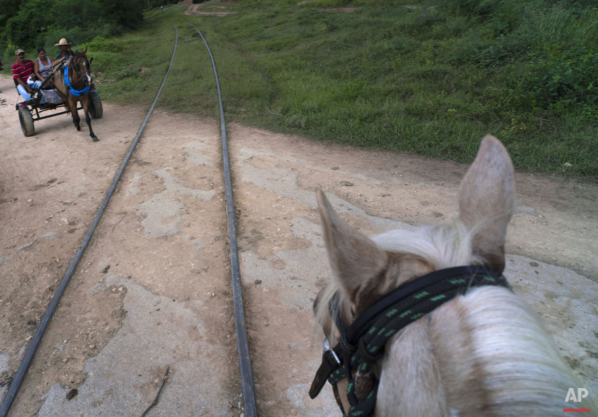  In this Oct. 12, 2015 photo, a family on a horse-drawn carriage crosses the train tracks that connect Trinidad with the "Valle de los Ingenios," or Valley of the Sugar Mills, in Cuba. After decades of neglect due to the fall of the sugar industry, d