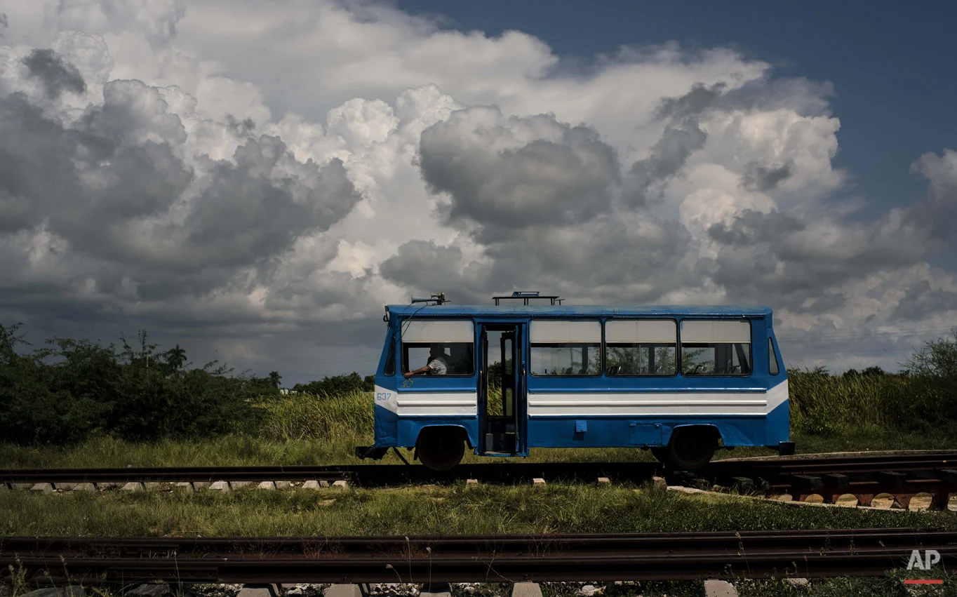 In this Oct. 11, 2015 photo, a train wagon made to look like a bus, moves along the tracks on the outskirts of Trinidad, Cuba. This train, known as a "train auto motor," moves passengers to and from the outskirts of the city. (AP Photo/Ramon Espinosa)