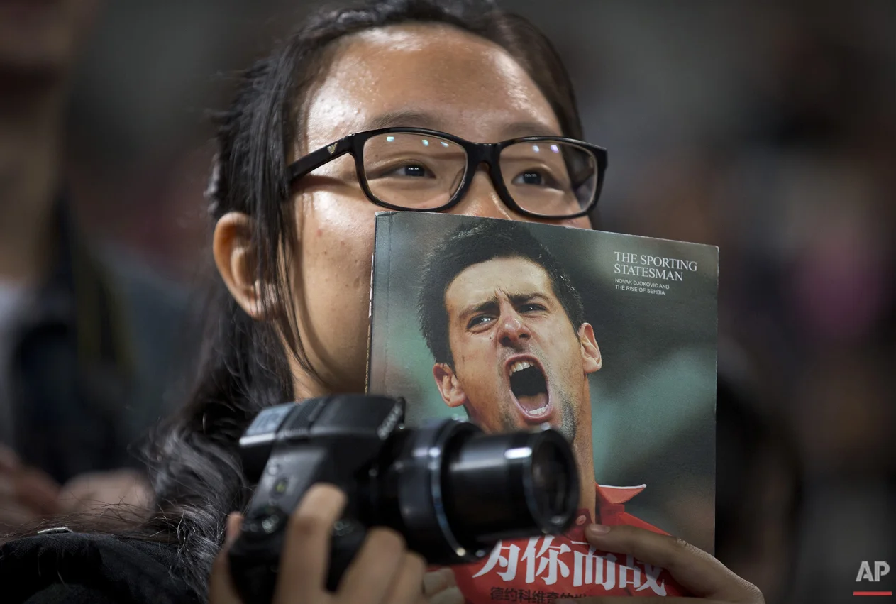A woman watches Novak Djokovic of Serbia plays at a charity promotion activity event for the China Open tennis tournament at the National Tennis Stadium in Beijing, Saturday, Oct. 3, 2015 (AP Photo/Andy Wong)