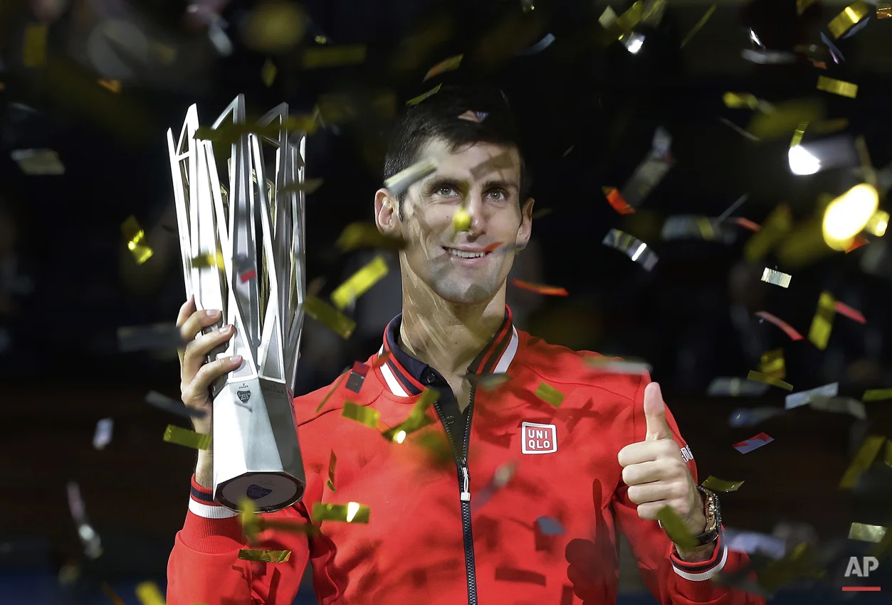 Novak Djokovic of Serbia gestures with his winner's trophy after he defeated Jo-Wilfried Tsonga of France in the final match of the Shanghai Masters tennis tournament at Qizhong Forest Sports City Tennis Center in Shanghai, China, Sunday, Oct. 18, 2015. (AP Photo/Andy Wong)