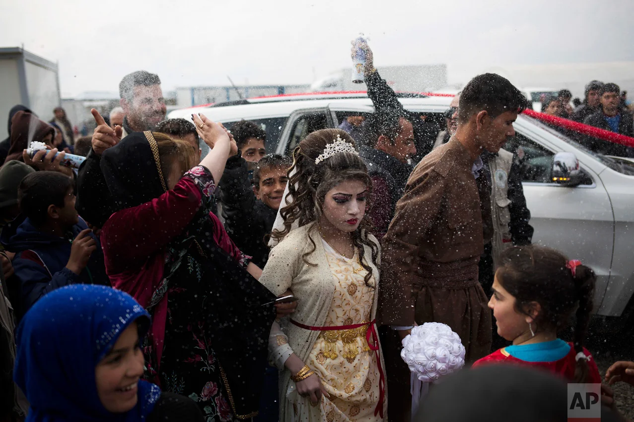 Hussein Zeino Danoon and Shahad Ahmed Abed arrive at the Khazer camp for people displaced from Mosul for their wedding on Thursday, Feb. 16, 2017. It's the second marriage to take place in the IDP camps east of the city where tens of thousands are living, having fled the fighting in Mosul. (AP Photo/Bram Janssen)