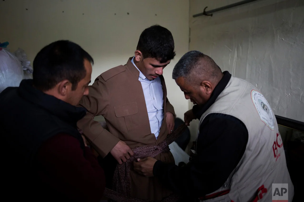 Hussein Zeino Danoon, 25, gets dressed in Kurdish traditional clothing for his wedding on Thursday, Feb. 16, 2017. He married 16-year-old Shahad Ahmed Abed in the Khazer camp for displaced people from Mosul. (AP Photo/Bram Janssen)