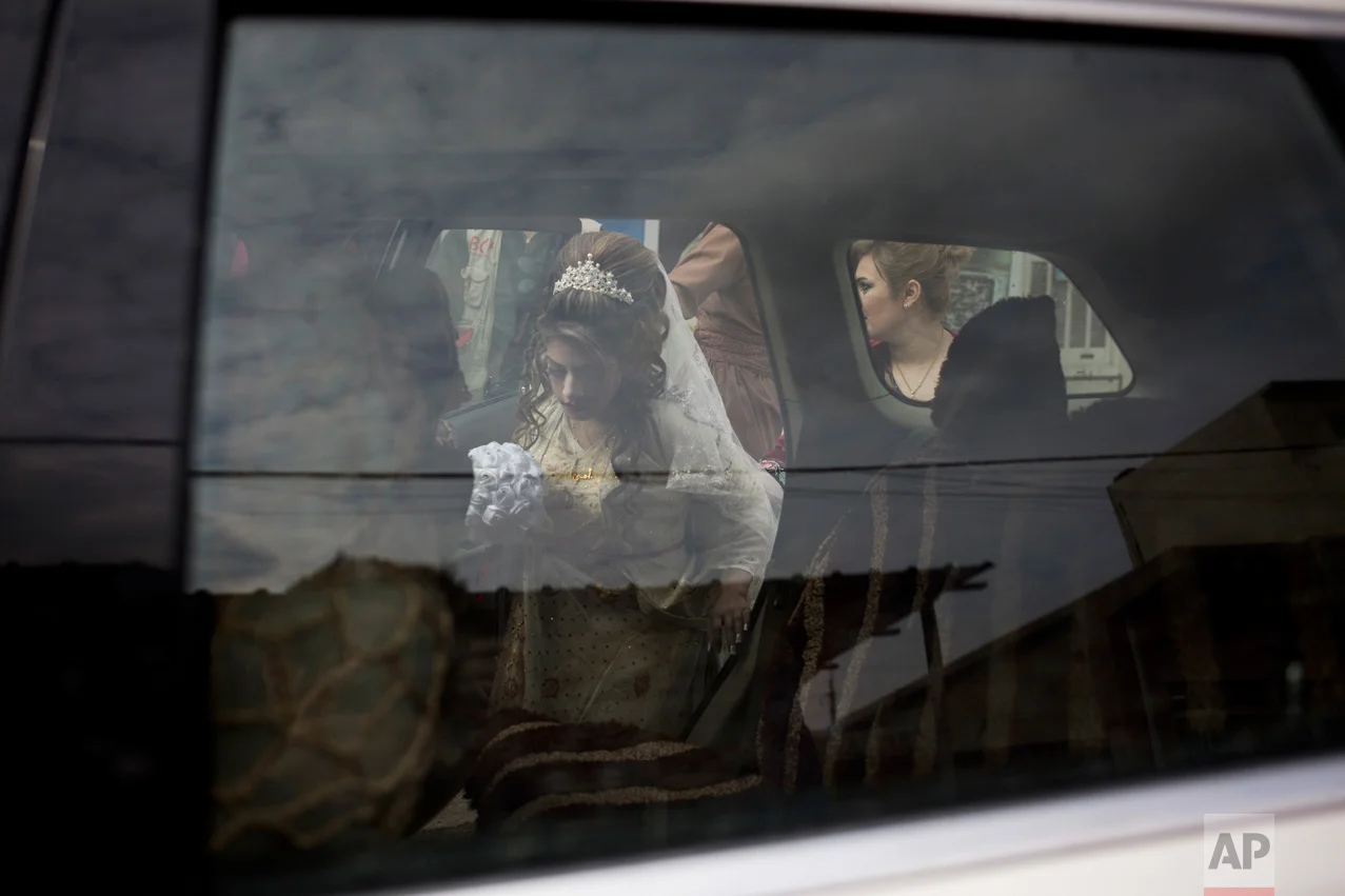 Shahad Ahmed Abed gets inside a car before driving to the Khazer camp for displaced people from Mosul where she was married on Thursday, Feb. 16, 2017. Abed and her 25-year-old husband Hussein Zeino Danoon fled from Mosul within the last month, just as Iraqi forces pushed Islamic State militants out of the eastern side of the city. (AP Photo/Bram Janssen)