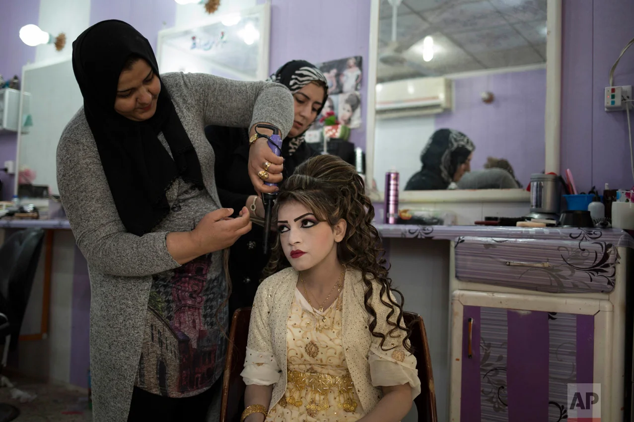 Shahad Ahmed Abed gets her hair done in a salon in Khazer for her wedding on Thursday, Feb. 16, 2017. Abed and her husband Hussein Zeino Danoon both fled from Mosul within the last month, just as Iraqi forces pushed Islamic State militants out of the eastern side of the city. (AP Photo/Bram Janssen)
