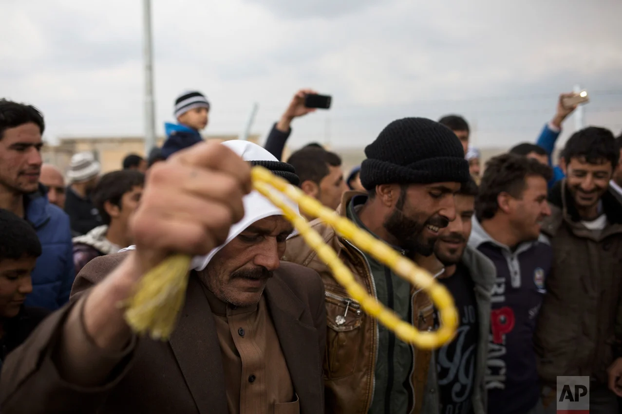 Displaced people from Mosul dance on traditional Kurdish music in the Khazer camp during a wedding on Thursday, Feb. 16, 2017. It's the second marriage to take place in the IDP camps east of the city where tens of thousands are living, having fled the fighting in Mosul. (AP Photo/Bram Janssen)