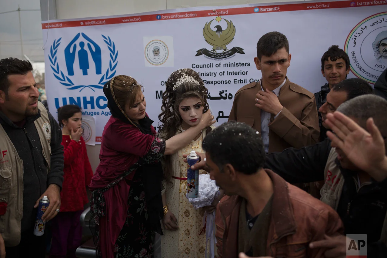 Hussein Zeino Danoon and Shahad Ahmed Abed are celebrated at their wedding in the Khazer camp for displaced people from Mosul, Thursday, Feb. 16, 2017. The wedding, organized and financed by the camp management, is the second marriage to take place in the IDP camps east of the city where tens of thousands are living, having fled the fighting in Mosul. (AP Photo/Bram Janssen)