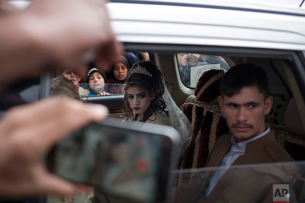 Hussein Zeino Danoon and Shahad Ahmed Abed sit inside the car after marrying in the Khazer camp for displaced people from Mosul, Thursday, Feb. 16, 2017. It's the second marriage to take place in the IDP camps east of the city where tens of thousands are living, having fled the fighting in Mosul. (AP Photo/Bram Janssen)