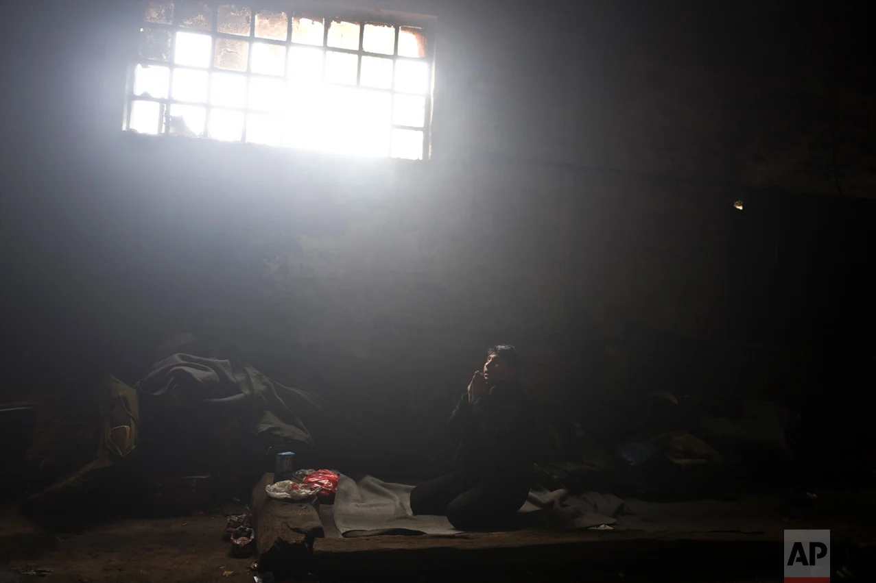In this Friday, Feb. 3, 2017 photo, unaccompanied minor Caesar, 16, a migrant from Pakistan's tribal area of Bajaur, prays in an abandoned warehouse where he and other migrants took refuge in Belgrade, Serbia. (AP Photo/Muhammed Muheisen)