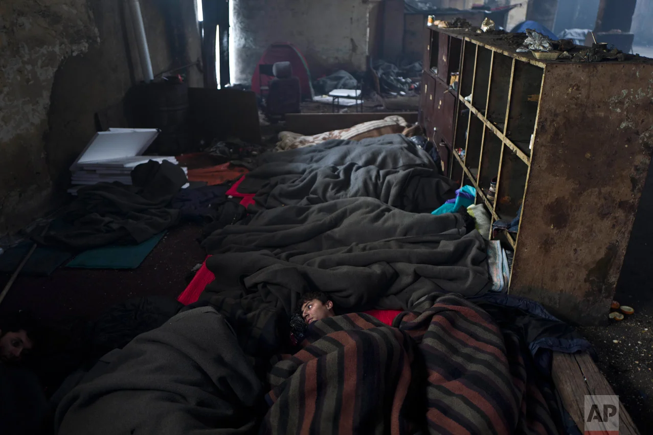 In this Wednesday, Feb. 1, 2017 photo, unaccompanied minor Murad, 12, a migrant from Laghman, Afghanistan rests on the ground of an abandoned warehouse where he and other migrants took refuge in Belgrade, Serbia. (AP Photo/Muhammed Muheisen)