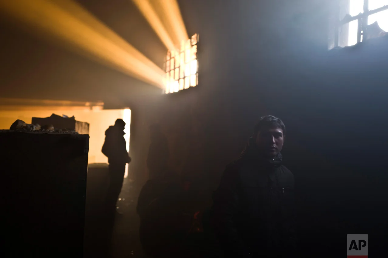 In this Monday, Jan. 30, 2017 photo, unaccompanied minor, Irfan, 17, a migrant from Pakistan's tribal area of Bajaur, stands in an abandoned warehouse where he and other migrants took refuge in Belgrade, Serbia. (AP Photo/Muhammed Muheisen)