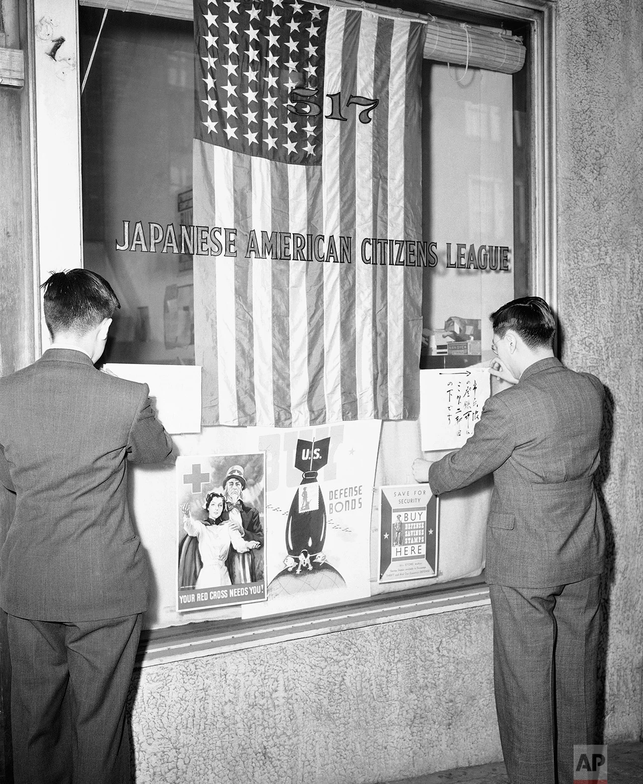 Officials of the Seattle Japanese - American Citizens League post signs outside league office March 11, 1942 notifying Seattle's Japanese population that all must register for themselves and their families. This is to facilitate possible future evacuation orders. (AP Photo)